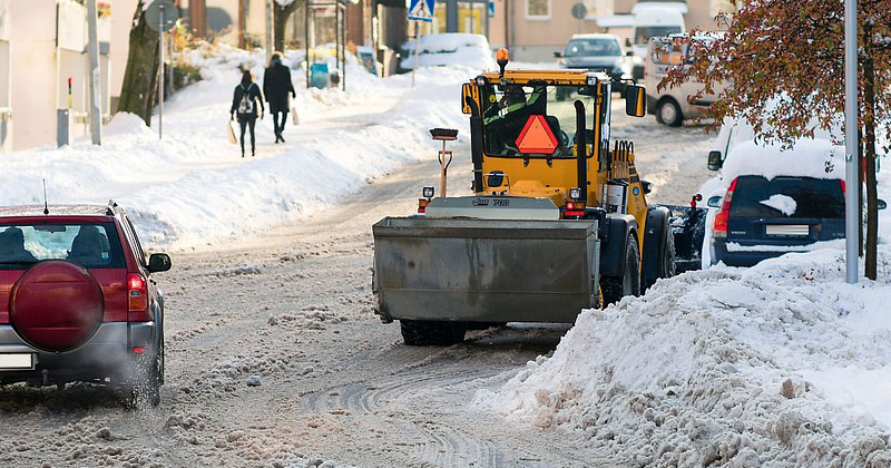 Snow plow plowing a street